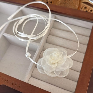 Detailed view of handmade organza camellia flower choker with pearl and satin ribbon