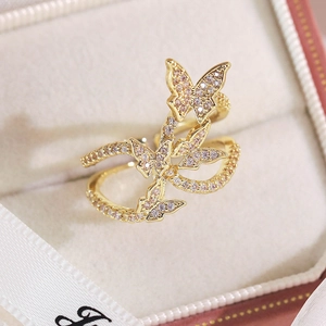 Macro de la bague papillon dorée sertie de zircons sur un coffret à bijoux en velours