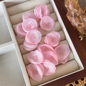 Close-up of pink organza mesh flower earrings with crystal beads in a jewelry box