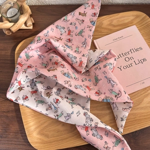Pink headscarf with cute cartoon dog patterns on a wooden tray with a book