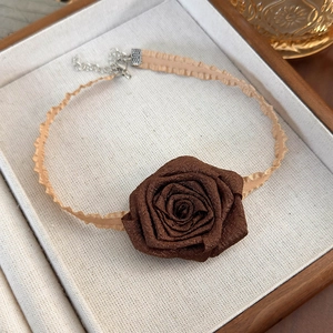 Close-up of dried rose choker with silk ribbon and adjustable silver clasp on jewelry box