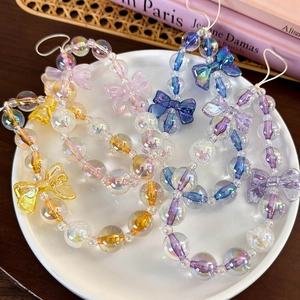 Detailed macro view of colorful translucent beaded phone charms with bow tie decorations