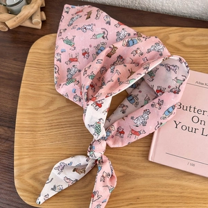 Close-up of pink cotton headscarf with cute dog illustrations and knotted detail
