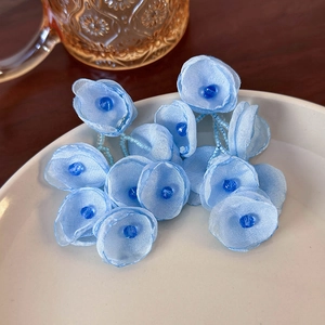 Detail of light blue mesh fabric flower earrings with navy bead stamens and chain