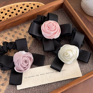 Dettaglio di elastici per capelli in raso con rosa e fiocco in rosa e crema