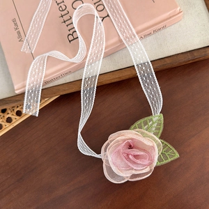 Détail macro d'un choker fleur de rose en maille 3D avec dentelle délicate à pois