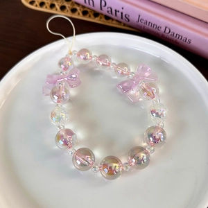 Detail shot of a handmade lavender beaded phone charm with iridescent bow and pastel beads