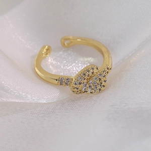 Détail macro d'une bague nœud dorée avec des cristaux de zircone cubique micro-pavés