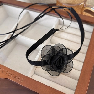 Detail of elegant black mesh rose choker necklace with satin ribbons in a jewelry box