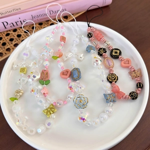 Détail de quatre chaînes de téléphone perlées avec des motifs de papillon et fleurs