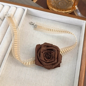 Detail view of a vintage satin rose choker with organza ribbon and adjustable silver clasp