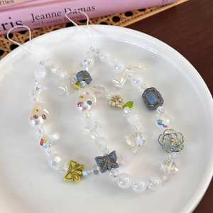 Détail de la dragonne de téléphone en perles colorées avec fleurs en résine et strass