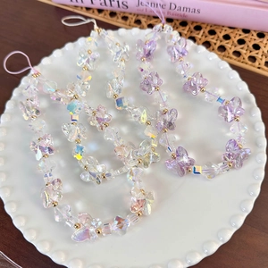 Detailed view of colorful butterfly beaded phone charms in a white ceramic dish