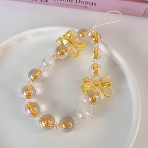 Detail of colorful beaded phone strap with yellow bows and translucent orange beads