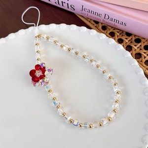 Close-up of iridescent cube beads and a red flower charm on a beaded phone wrist strap