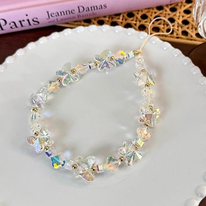 Detail view of pearlescent butterfly beads and golden spacers on the phone wrist strap