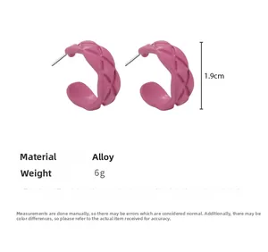 Detail view of pink C-shaped alloy hoop earrings featuring a unique quilted texture pattern