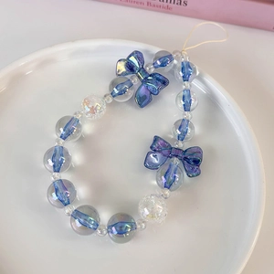 Detailed close-up of blue iridescent bow pendants and beads for phone strap