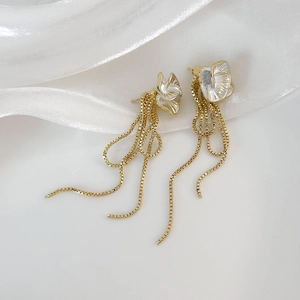 Élégantes boucles d'oreilles camélia à pampilles en métal doré et pétales blancs