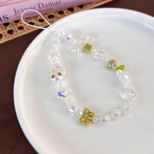 Gros plan sur la dragonne de téléphone en perles colorées avec un charmant papillon jaune