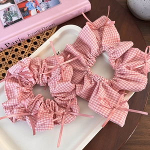 Detail of pink gingham scrunchies with ribbon bows on a white tray set decor