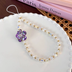 Detail of colorful glass square beads and purple crystal flower on a stylish phone lanyard