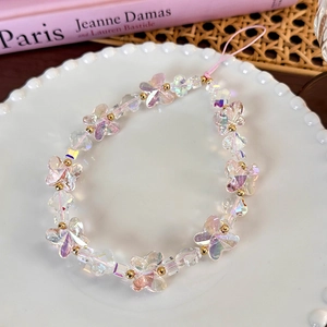 Detail shot of colorful butterfly beads and faceted gems on a pink phone charm wrist strap