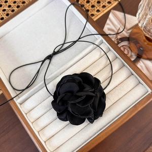 Détails de la fleur de camélia en tissu noir dans un coffret cadeau en bois élégant