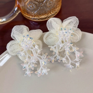 Detailed macro view of organza mesh floral earrings with beaded tassel fringe