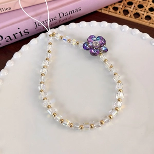 Detailed macro view of colorful square glass beads and a purple iridescent flower charm
