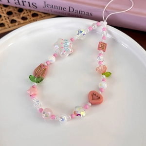 Détail d'un cordon de téléphone en perles colorées avec cœurs roses et breloques étoiles