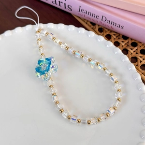 Detail of colorful glass beads and blue gradient crystal flower charm on white cord