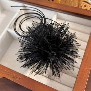 Detail of multi-layer black mesh flower choker showing delicate pleated gauze texture