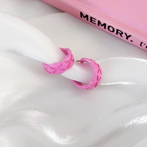 Pink quilted C-shaped hoop earrings with elegant enamel finish on white silk background
