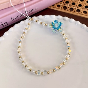 Detail view of colorful glass beads and crystal flower charm on a wrist strap