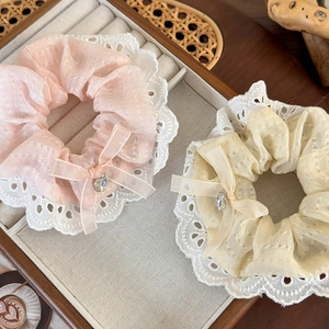Detailed view of lace scrunchies with chiffon bows and heart rhinestones on a jewelry tray