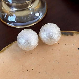 Dettaglio di perle di cotone bianche con texture rugosa su un vassoio di ceramica
