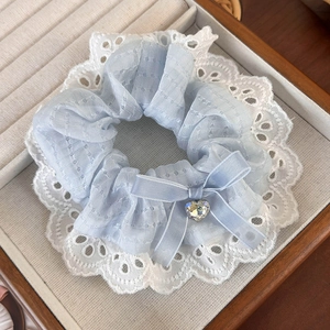 Detail of light blue lace scrunchie with ribbon bow and sparkling crystal heart pendant
