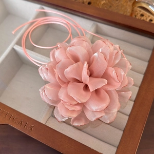Close-up of pink satin flower choker with intricate silk petals and ribbon detail