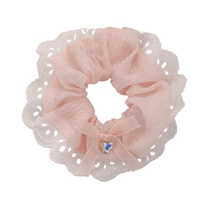 Pink lace scrunchie with a ribbon bow and iridescent heart rhinestone on white background