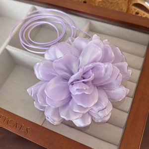 Detailed view of handmade purple silk flower choker with silky pearl texture