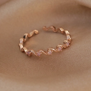 Detail of rose gold wavy adjustable ring with pink opal inlay on champagne silk