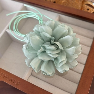 Detail shot of a mint green satin handmade flower choker with delicate silk petals