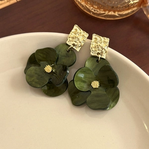 Detailed shot of dark green marble resin flower earrings with gold textured metal studs