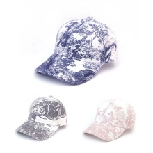 Detailed close-up of three Toile de Jouy print baseball caps in navy, charcoal and pink