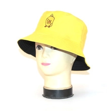 Detail of yellow and black reversible bucket hat with a cartoon embroidery on head model