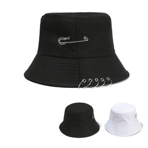 Detail of black cotton bucket hat featuring decorative silver safety pin and metal rings