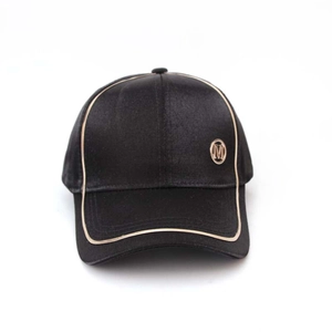 Close-up of black satin baseball cap featuring a golden metallic M logo and yellow piping