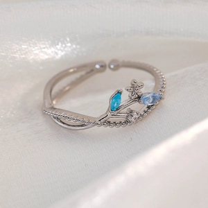 Detail of adjustable silver ring with blue marquise stones and floral zircon design