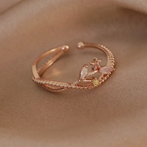 Detail of rose gold twig ring with marquise zircons on silk fabric background